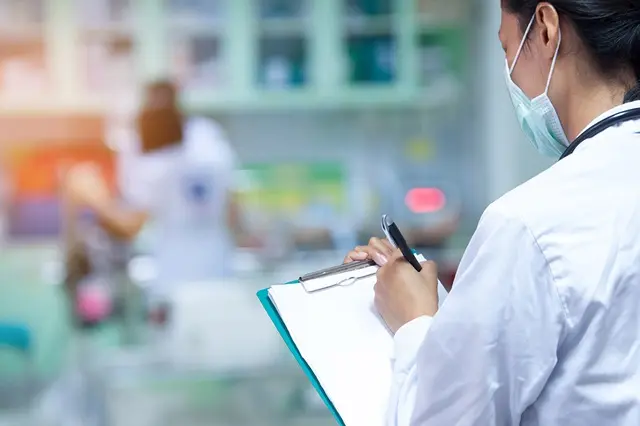 Doctor writing a medical prescription in hospital