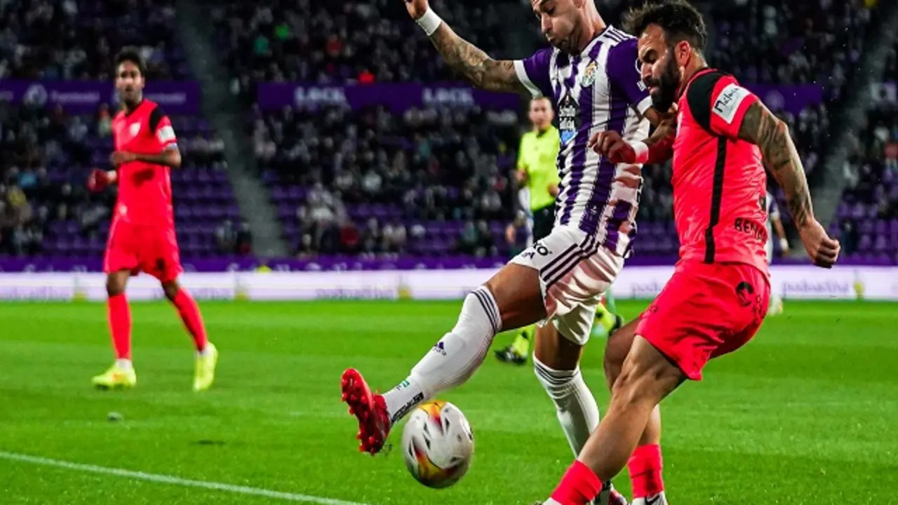 Sergio Le&oacute;n disputando un bal&oacute;n ante el jugador malaguista | Fuente: Real Valladolid